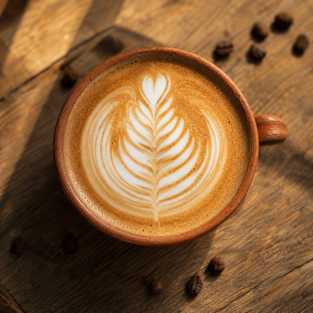 Flat white with rosetta latte art in a terracotta cup